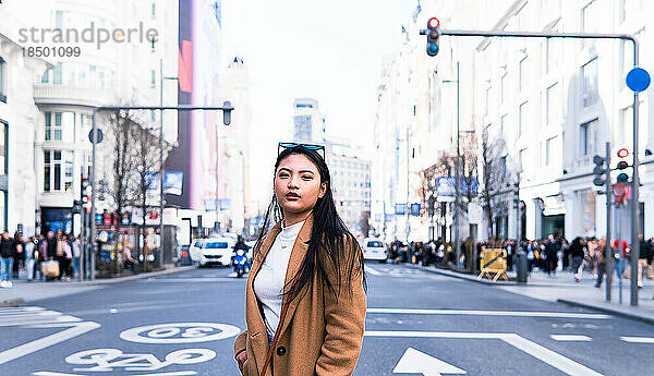 Asiatisches Mädchen überquert die Straße der Gran Via in Madrid