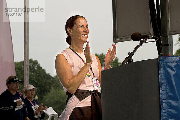 Woman speaks at podium at a breast cancer walk in Washington DC.