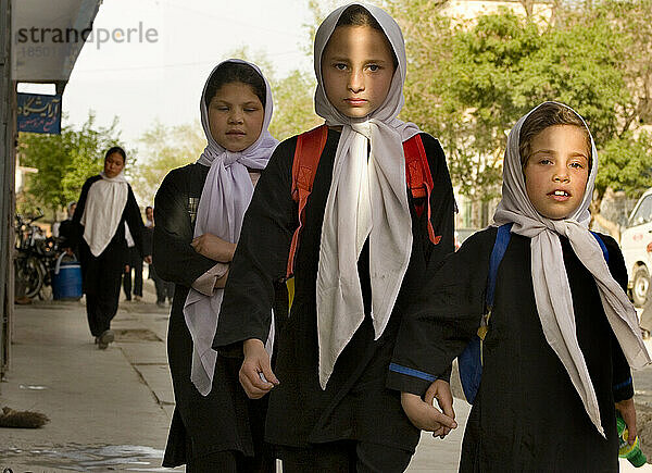 Mädchen mit weißen Kopftüchern gehen nach dem Unterricht in Kabul von der Schule nach Hause.