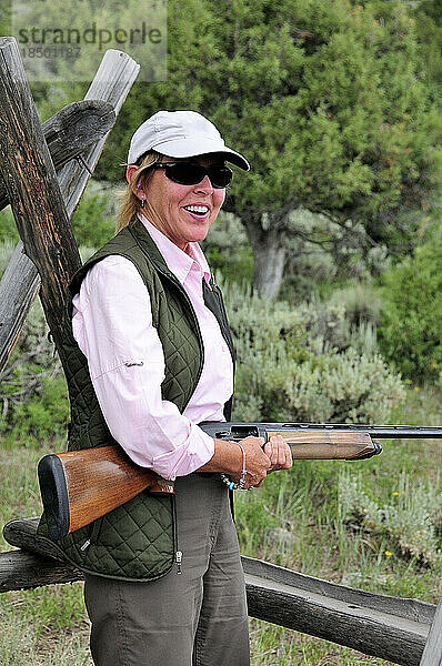Eine Frau schießt in den Bergen Colorados auf Tontauben