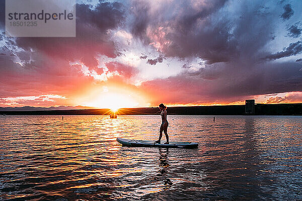 Teenager paddeln bei Sonnenuntergang