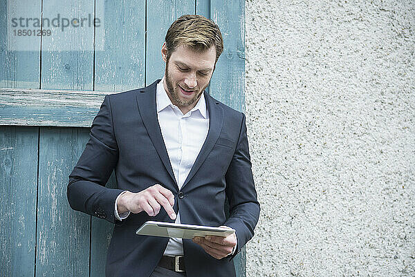 Mittlerer erwachsener Geschäftsmann nutzt digitales Tablet draußen  Bayern  Deutschland