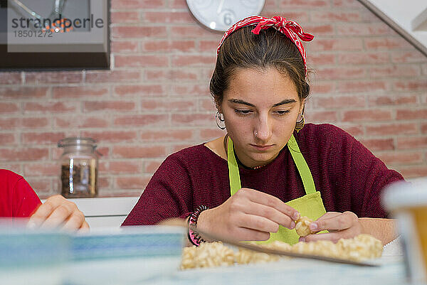 Fröhlicher Teenager konzentriert sich auf die Arbeit mit traditioneller katalanischer Sprache