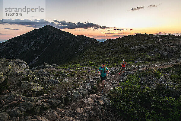Trailrunner laufen bei Sonnenaufgang über den Franconia Ridge