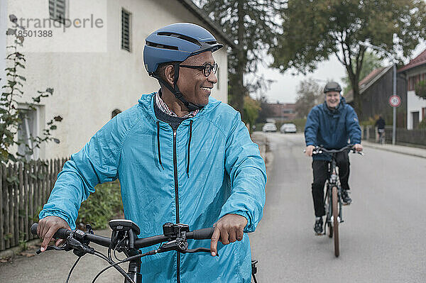 Male friends cycling on road  Bavaria  Germany