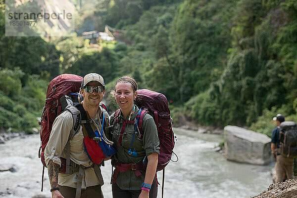 Glückliches Wanderpaar  das vor dem Fluss im Dschungel steht