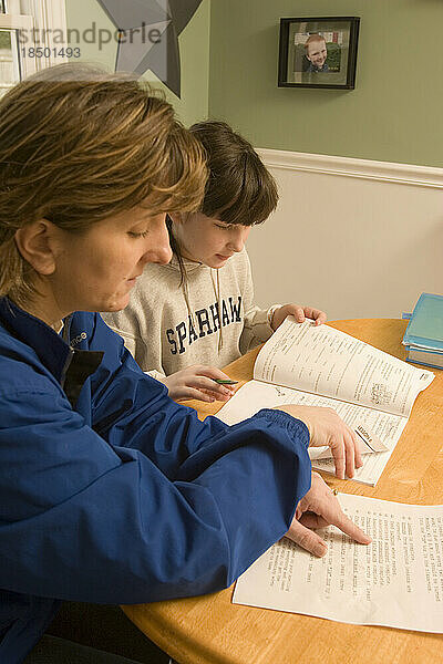 Eine Mutter hilft ihrer zehnjährigen Tochter bei den Hausaufgaben.