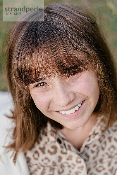 Vertikales Porträt eines lächelnden kaukasischen Teenager-Mädchens im Alter von 12 Jahren