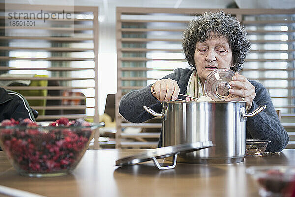 Ältere Frau bereitet Marmelade im Pflegeheim zu