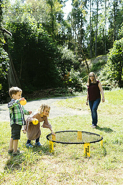 Kinder spielen gemeinsam auf einem Campingplatz  während ihre Mutter zusieht
