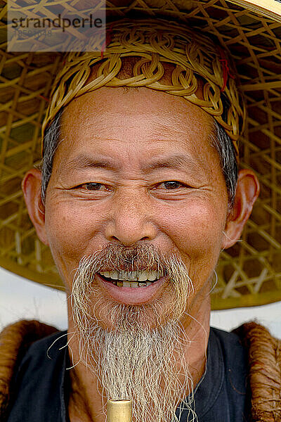 Porträt eines alten Fischers  der in traditioneller Tracht in Yangshuo  China  raucht