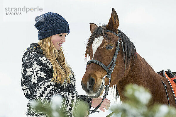 Teenager-Mädchen mit Pferd im Ackerland im Winter  Bayern  Deutschland