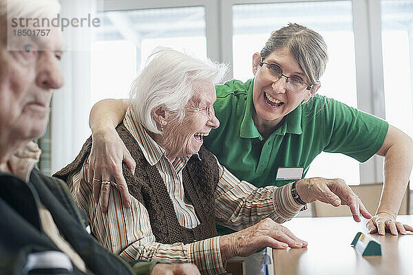 Krankenschwester und ältere Frau haben Spaß im Pflegeheim
