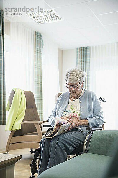 Ältere Frau liest Zeitschrift im Altersheim