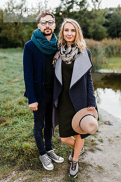 Ein Mann und eine Frau in Mänteln gehen bei einem Date durch einen Herbstpark