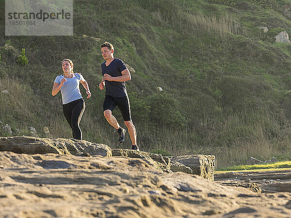 Mann und Frau joggen auf Singletrail