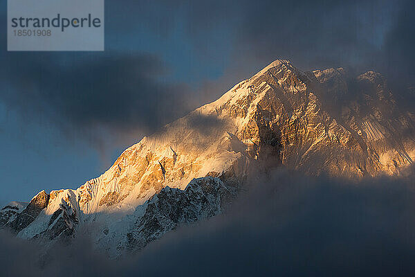 Der Nuptse-Gipfel der Everest-Region ist bei Sonnenuntergang in Wolken gehüllt.