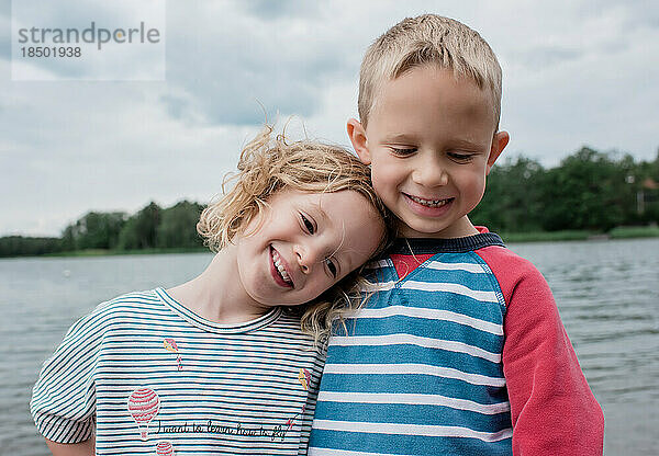 Bruder und Schwester kuscheln im Sommerurlaub am Strand