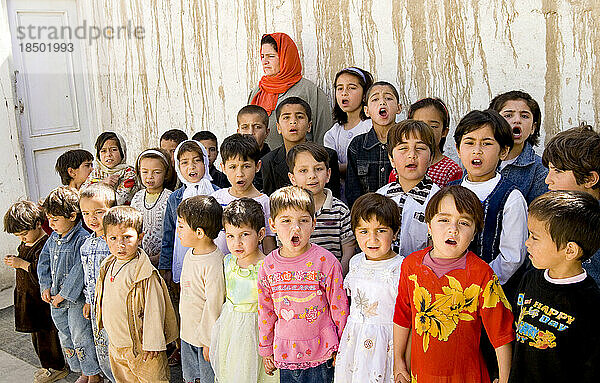 Eine Lehrerin sieht zu  wie Kinder in einer Kindertagesstätte in Kabul ihren Tag mit Hymnen und Liedern beginnen.