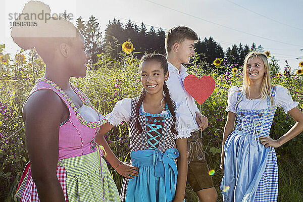 Glückliche Teenager-Freunde vor Sonnenblumenfeld  Bayern  Deutschland