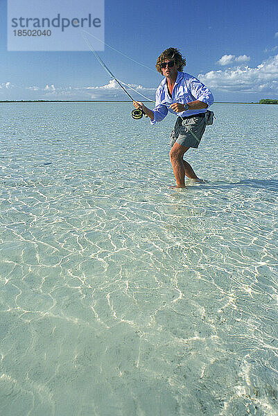 Ein Salzwasser-Fliegenfischer wirft auf einen Fisch im seichten Wasser.