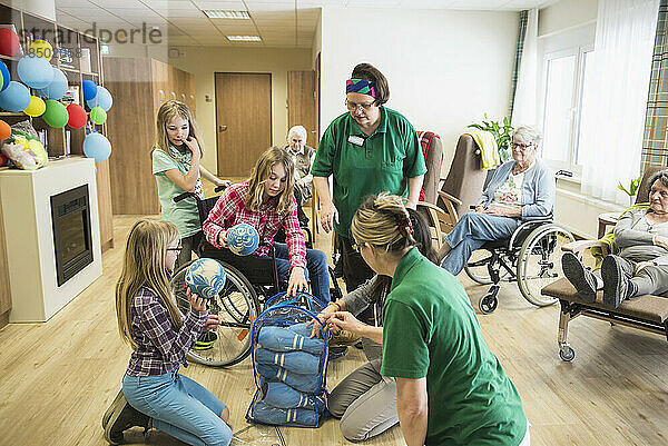Mädchen packen Bowlingausrüstung mit Krankenschwester im Pflegeheim