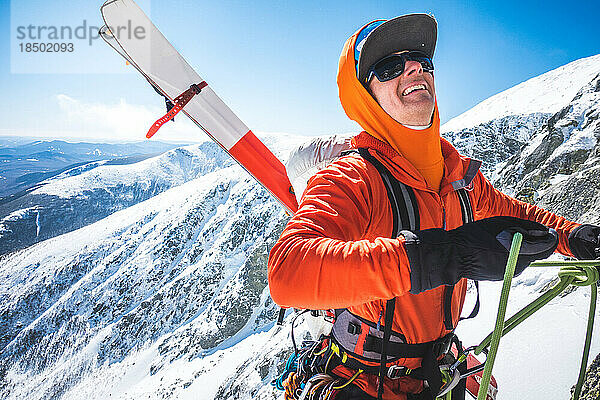 Skibergsteiger organisiert Seile mit schneebedeckten Bergen dahinter