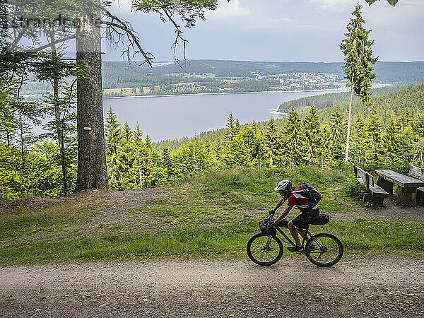 Mountainbiker radelt am See im Hintergrund bei Schluchsee  Baden-Württemberg  Deutschland