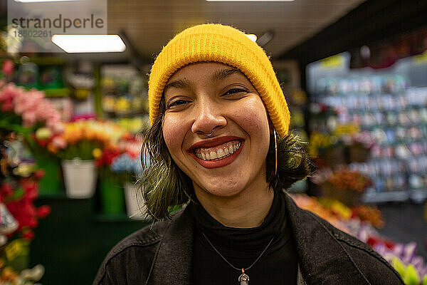 Junge Frau mit Lächeln im Gesicht im Floristen. Arbeiter im Blumenposten.