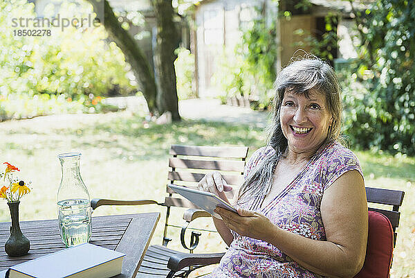 Ältere Frau mit einem digitalen Tablet im Garten  Altötting  Bayern  Deutschland