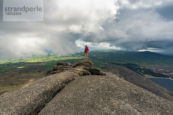 Frau steht auf dem Gipfel der Slieve Binnian Mountains