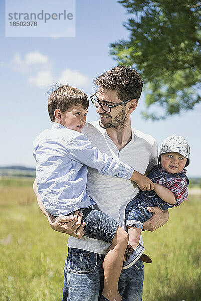 Glücklicher Mann mit seinem Sohn beim Picknick auf dem Land  Bayern  Deutschland
