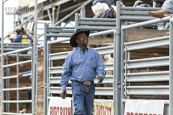 Ein Cowboy lächelt einige Kumpel auf der Tribüne beim Rodeo an