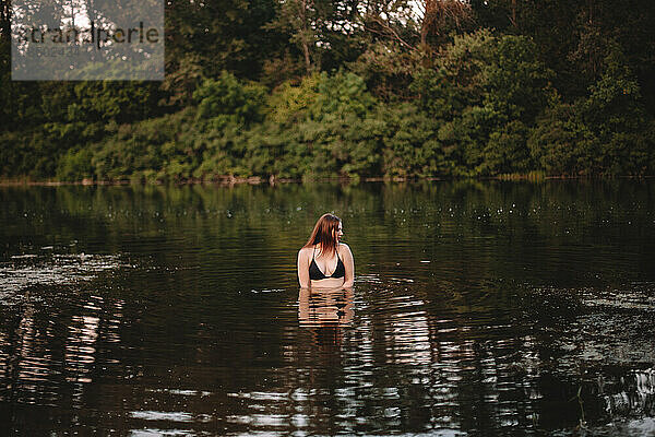 Sinnliche Frau steht im See im Wald