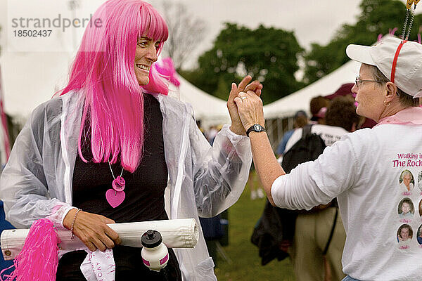 Walker gets high fives from fellow participant in a breast cancer walk.