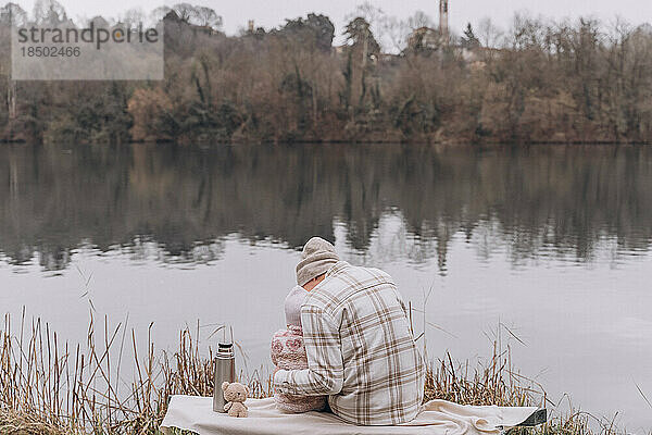 Vater und kleines Mädchen verbringen im Frühjahr Zeit miteinander in der Nähe des Flusses