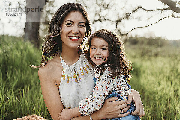 Porträt von Mutter und Tochter im Hintergrundbeleuchtungsfeld  die in die Kamera lächeln