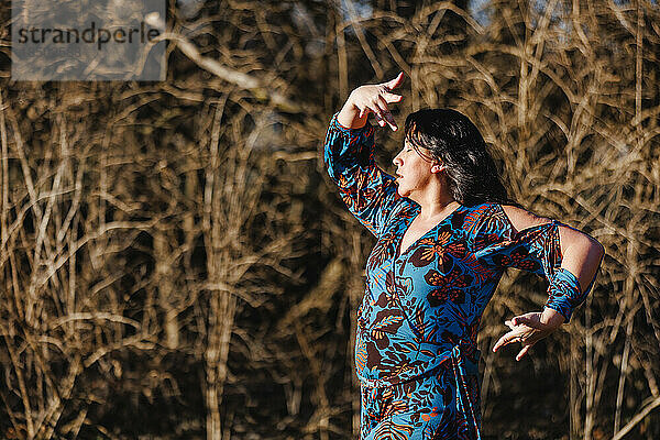 Eine leidenschaftliche Frau tanzt draußen im Sonnenlicht Flamenco