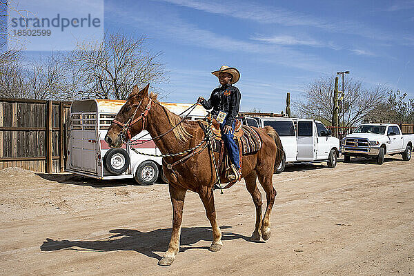 Eine junge Reiterin wärmt ihr Pferd hinter der Bühne beim Arizona Black Rodeo auf