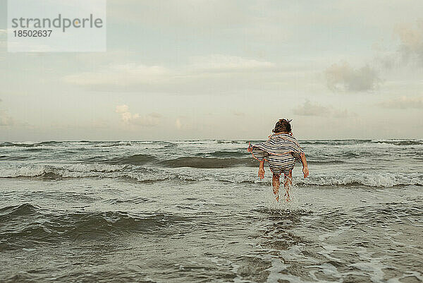 Mädchen springt in Wellen am Strand in Corpus Christi  Texas