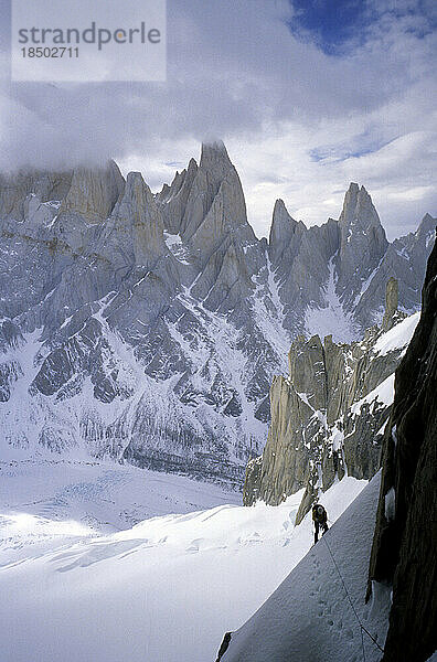 Kletterer an der Ostwand des Cerro Torre mit den Gipfeln Aguja Poincenot  Aguja Rafael und Aguja Saint Exupery im Hintergrund.