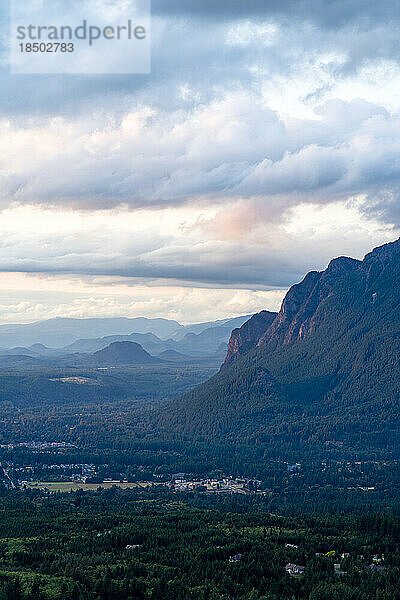 Bewölkter Sommersonnenuntergang am Mt. Si  Washington mit einer kleinen Stadt am Fuß