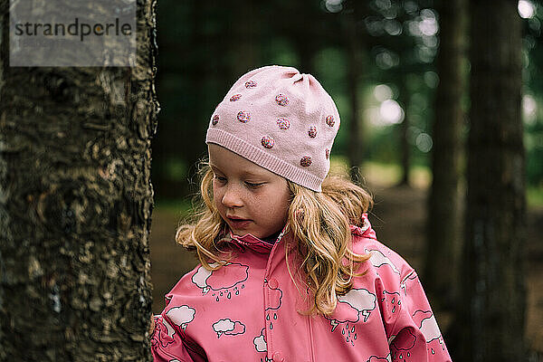 Blondes Kind in rosa Kleidung im Wald
