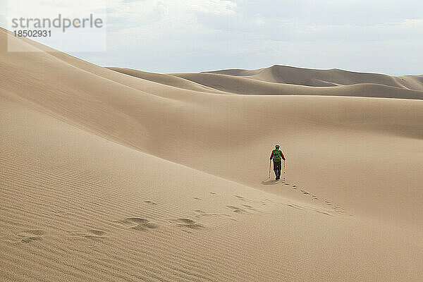 Mann wandert über eine Sanddüne