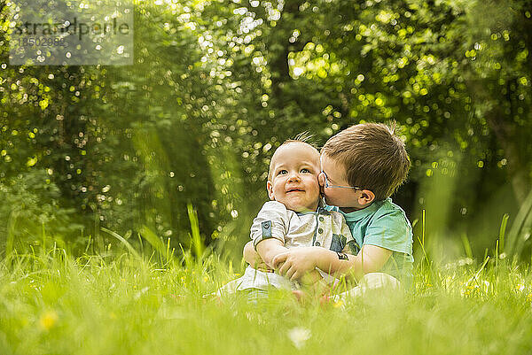 Zwei kleine Brüder amüsieren sich im Garten