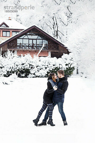 Liebespaar tanzt im verschneiten Park