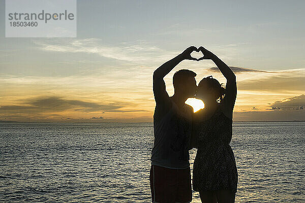 Silhouette eines Paares  das mit den Händen eine Herzform macht  Nusa Lembongang  Bali  Indonesien