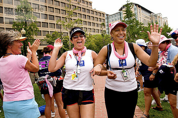 Women get high fives as they finish a breast cancer walk in Washington DC.