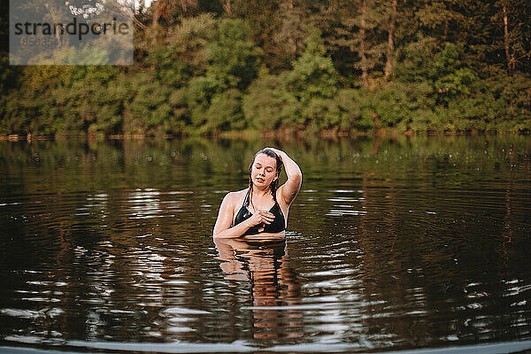 Junge Frau taucht aus dem Wasser auf