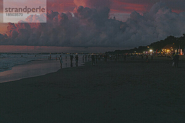 Menschen am Meeresstrand beobachten den Sonnenuntergang. Bali  Indonesien.